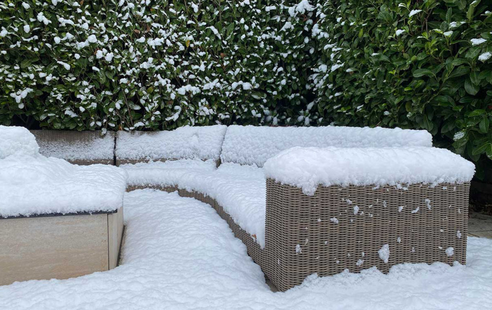 Rattan garden furniture covered by snow